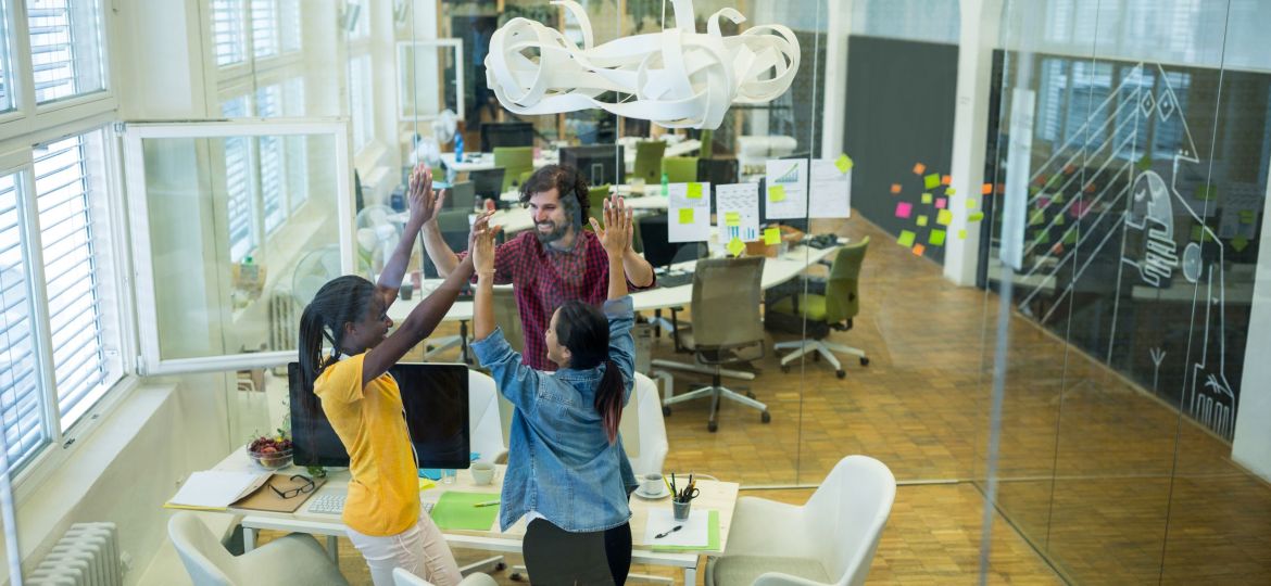 Group of graphic designers giving high five to each other