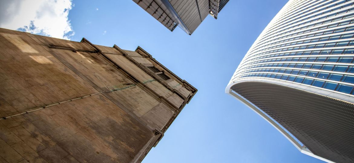 Shot of a tall aged and modern buildings against a blue sky background